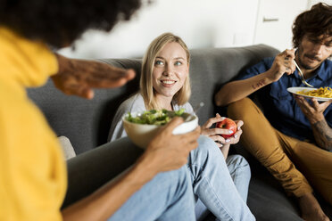 Freunde sitzen auf der Couch, reden und essen - VABF01889