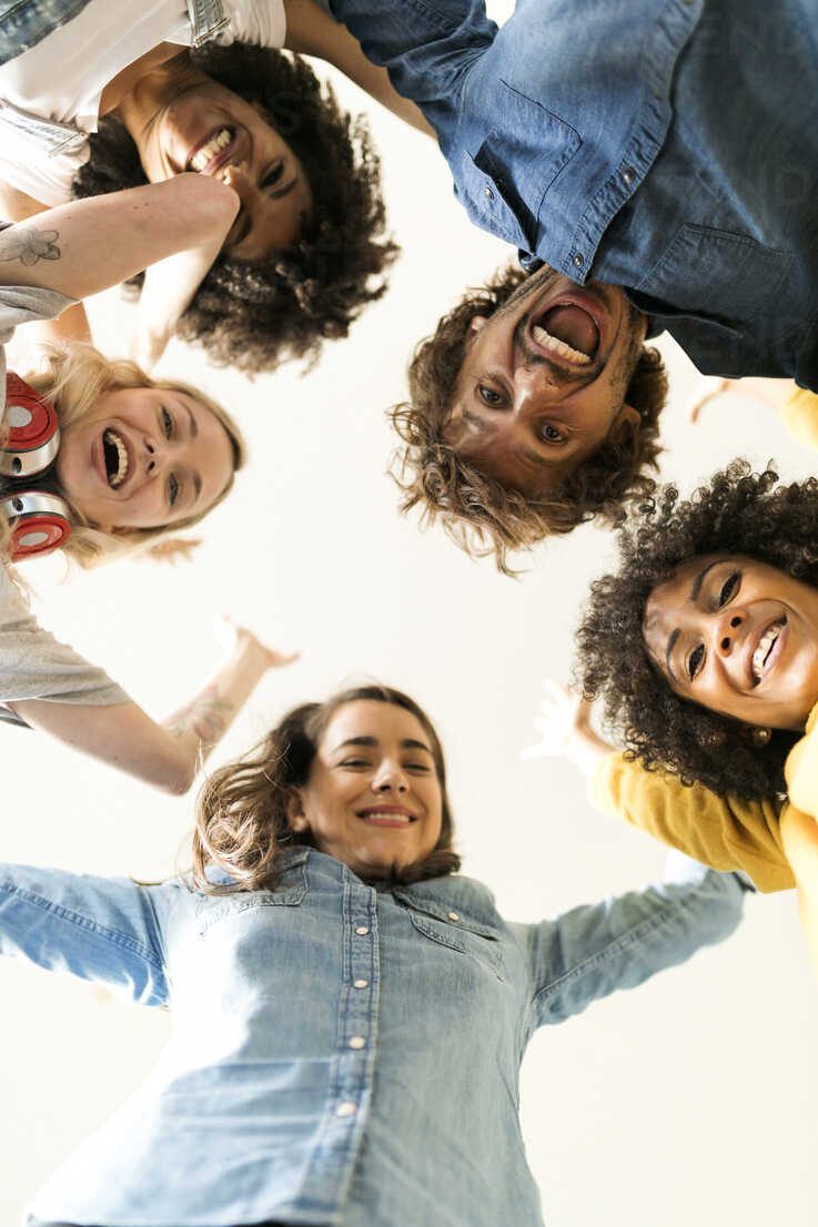 Group Portrait Of Cheerful Friends Huddling Stock Photo