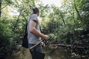 Rückenansicht eines jungen Mannes beim Fischen im Wald - VPIF01159