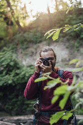 Junger Wanderer beim Fotografieren in einem Wald - VPIF01174