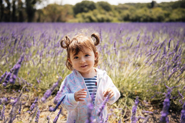 France, Grignan, portrait of smiling baby girl standing on lavender field - GEMF02589