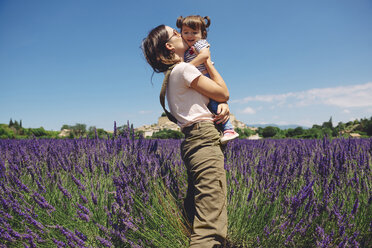 Frankreich, Grignan, Mutter küsst kleine Tochter im Lavendelfeld - GEMF02619