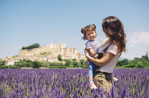 France, Grignan, portrait of happy baby girl together with her mother in lavender field stock photo