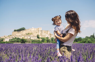 Frankreich, Grignan, Porträt eines glücklichen kleinen Mädchens zusammen mit seiner Mutter in einem Lavendelfeld - GEMF02624