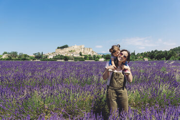 France, Grignan, happy mother carrying her little daughter through lavender field - GEMF02627