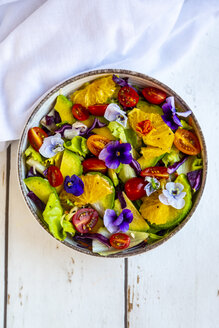 Schüssel mit gemischtem Salat mit Avocado, Tomaten und essbaren Blüten - SARF03983