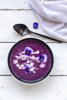 Bowl of creamed red cabbage soup garnished with edible flowers - SARF03985