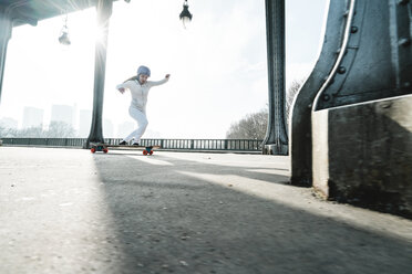 Volle Länge der Frau Skateboarding unter Brücke gegen Himmel - CAVF56761