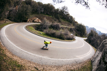 High angle view of man skateboarding on hairpin Curve road against sky - CAVF56766
