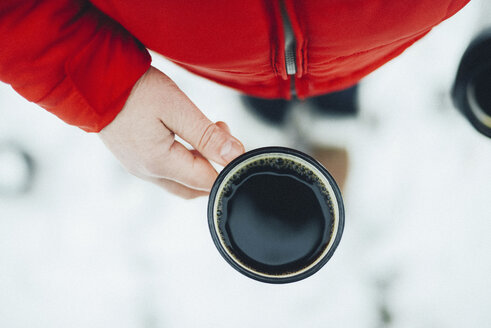 Midsection of woman holding mug with black coffee during winter - CAVF56792