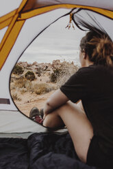 Rückansicht einer Frau, die im Zelt sitzend die Aussicht betrachtet - CAVF56812