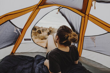 Rückansicht einer Frau, die beim Entspannen im Zelt die Aussicht betrachtet - CAVF56813