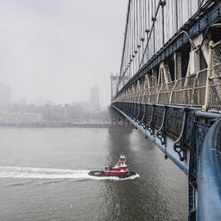 Manhattan Bridge over East River against sky during foggy weather - CAVF56842