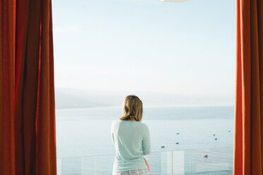 Frau schaut auf das Meer, während sie auf dem Balkon gegen den Himmel steht - CAVF56927