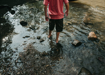 Low section of boy standing in lake - CAVF56984