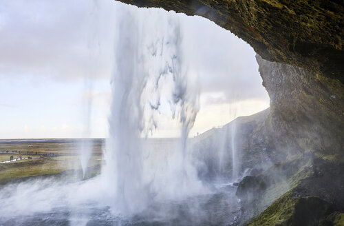 Blick auf den Seljalandsfoss Wasserfall gegen den bewölkten Himmel durch die Höhle gesehen - CAVF57017