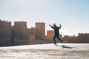 Volle Länge des Mannes Skateboarding gegen Schloss während sonnigen Tag - CAVF57057