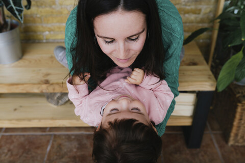 Hohe Winkel Ansicht der Mutter spielt mit Tochter, während auf dem Tisch zu Hause sitzen, lizenzfreies Stockfoto