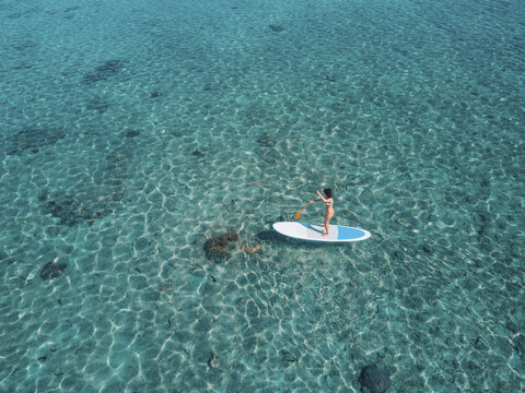 Hohe Winkel Ansicht der Frau Paddleboarding auf dem Meer, lizenzfreies Stockfoto