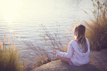 Mädchen meditiert sitzend am See - CAVF57202
