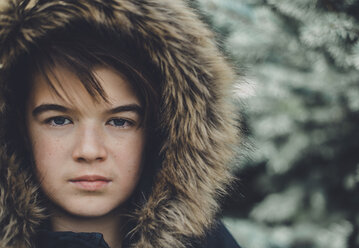 Close-up portrait of confident boy wearing fur coat during winter - CAVF57236