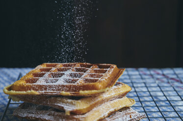 Nahaufnahme von Puderzucker auf einer Waffel vor schwarzem Hintergrund - CAVF57286