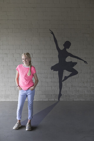 Portrait of laughing blond girl and shadow of ballerina in the background stock photo