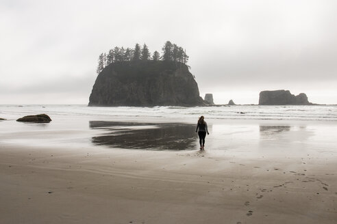 Rückansicht einer am Strand stehenden Frau bei bewölktem Himmel im Olympic National Park - CAVF57379