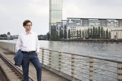 Deutschland, Berlin, Porträt eines Geschäftsmannes, der sich an der Spree entspannt - FKF03109