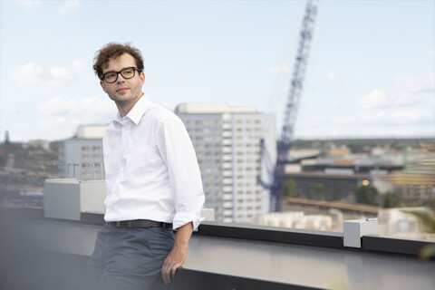 Deutschland, Berlin, Porträt eines zufriedenen Geschäftsmannes auf einer Dachterrasse, lizenzfreies Stockfoto