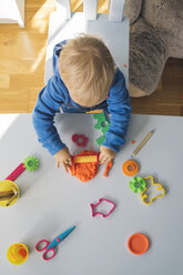 Baby girl playing with modeling clay, top view - MOMF00555