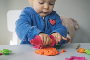 Baby girl playing with modeling clay - MOMF00556