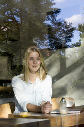 Portrait of blond woman in a cafe looking out of window - LMJF00014