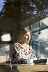 Portrait of blond woman working on laptop in a cafe - LMJF00019