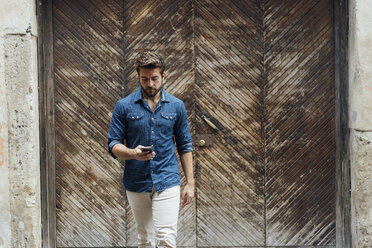 Bärtiger Mann schaut auf Smartphone - BOYF01078