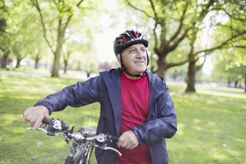 Aktiver älterer Mann fährt Fahrrad im Park, lizenzfreies Stockfoto