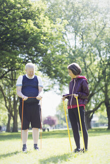 Aktives älteres Paar, das im sonnigen Park mit Widerstandsbändern trainiert und sich dehnt - CAIF22307