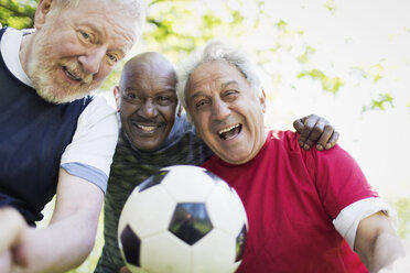 Portrait active senior men friends playing soccer - CAIF22308