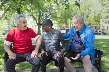 Active senior men friends talking on park bench - CAIF22321