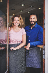 Portrait of smiling colleagues standing at store entrance - MASF09751