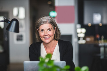 Portrait of confident businesswoman sitting at desk in creative office - MASF09970