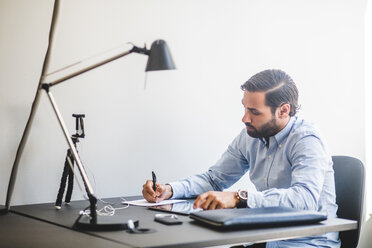 Kreativer Geschäftsmann arbeitet am Schreibtisch im Büro - MASF10043