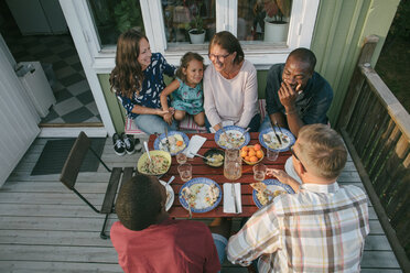 High angle view of multi-generation family having lunch at table on porch - MASF10089