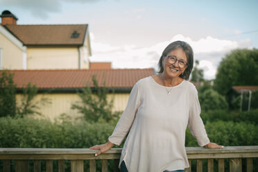 Porträt einer älteren Frau, die an einem Geländer auf einer Veranda steht - MASF10092