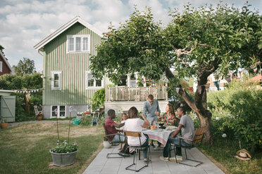 Mehrgenerationenfamilie genießt Getränke auf der Terrasse während einer Gartenparty - MASF10103