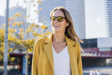 Portrait of smiling woman wearing sunglasses in the city - GIOF04868