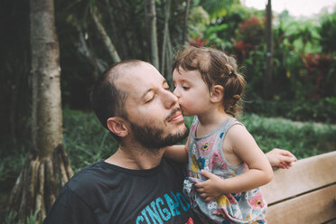 Kleines Mädchen küsst ihren Vater auf die Wange in einem Park - GEMF02637