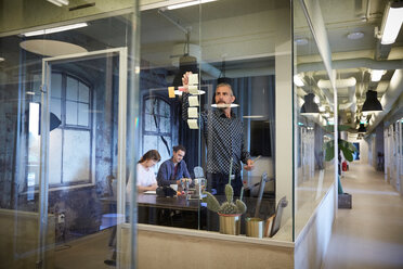 Kreative Geschäftsleute arbeiten im Sitzungssaal durch Glas gesehen - MASF10194