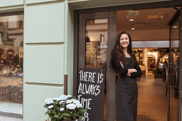 Porträt einer lächelnden Verkäuferin, die in einer Boutique am Eingang steht - MASF10261