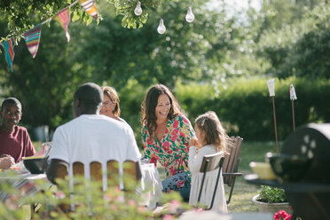 Glückliche Mehrgenerationenfamilie beim gemeinsamen Mittagessen auf der Terrasse während eines Gartenfestes - MASF10278